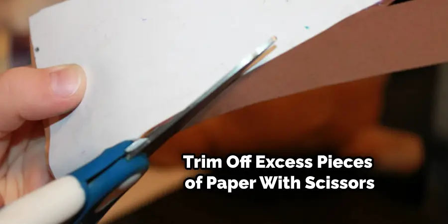 Trim Off Excess Pieces of Paper With Scissors